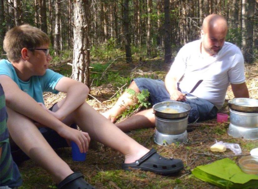 Matlagning pågår i skogen i stormkök.