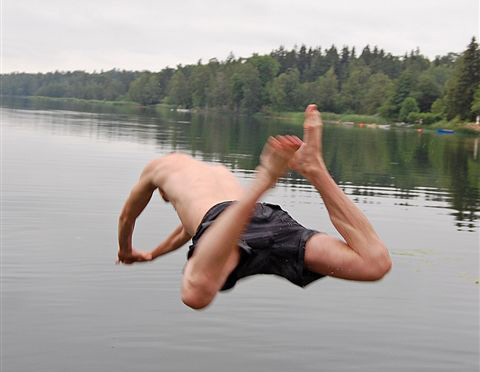 Person som hoppar från bryggan ner i sjön
