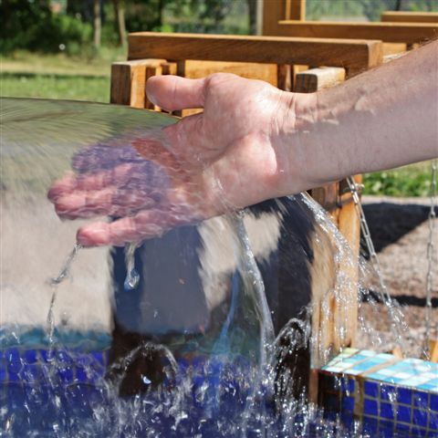 En hand som upptäcker vatten i vår Upplevelseträdgård